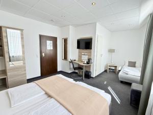 a hotel room with a bed and a desk in it at Hotel Hohenstaufen in Koblenz
