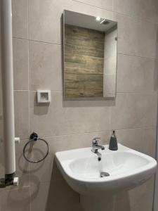 a bathroom with a white sink and a mirror at Le gris Perle in Sfax +21 photos
