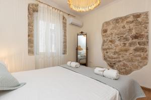 a bedroom with a large bed and a stone wall at Aila Stay in Corfu
