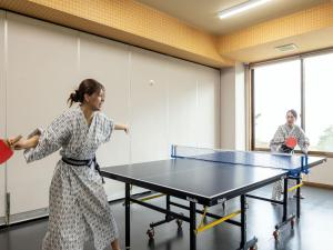 a woman playing a game of table tennis at YU-FURI Nasu-Takao Onsen Lodge in Nasu