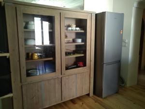 a large wooden cabinet next to a refrigerator at Appartement 48 m2 in Villeneuve-lès-Béziers