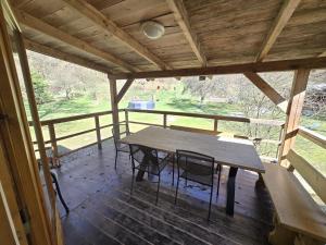 a wooden table and chairs in a screened in porch at Pod modříny in Adršpach