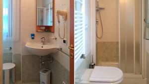 a bathroom with a sink and a toilet and a shower at Appartamenti Ciesa Padon in Rocca Pietore