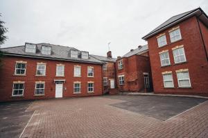 an empty parking lot in front of a brick building at Dalby House in Derby
