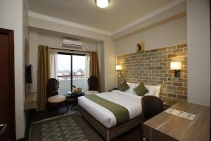 a hotel room with a bed and a desk and a window at Hotel Arts Kathmandu in Kathmandu +116 photos