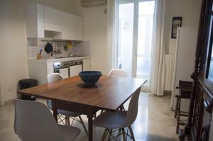 a kitchen with a wooden dining table and chairs at Piccinni house in Bari