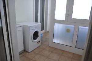 a laundry room with a washing machine next to a door at Piccinni house in Bari