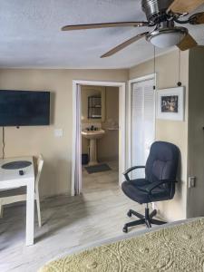 a living room with a blue chair and a desk at Studio Efficiency Apartment - a peaceful retreat in Port St Lucie in Port Saint Lucie