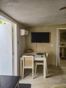 a dining room with a white table and a tv at Studio Efficiency Apartment - a peaceful retreat in Port St Lucie in Port Saint Lucie +21 photos