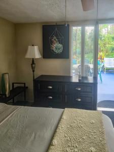 a bedroom with a bed and a dresser with a lamp at Studio Efficiency Apartment - a peaceful retreat in Port St Lucie in Port Saint Lucie