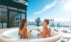 two women sitting in a hot tub on a building at Hotel Aqua Citta Naha in Naha
