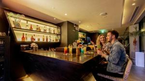 a man and a woman sitting at a bar at Hotel Aqua Citta Naha in Naha