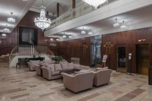 a lobby with couches and a staircase in a building at OREA Spa Hotel Bohemia Mariánské Lázně in Mariánské Lázně