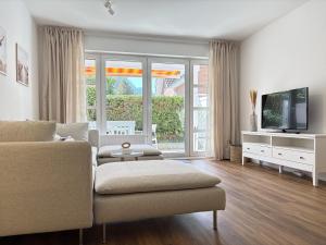 a living room with a couch and a tv at Allee 1G - Meerzeit in Dahme