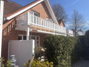 a house with a porch with a white deck at Allee 1G - Meerzeit in Dahme