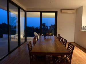 a dining room with a large wooden table and chairs at Maison des Alizés in Oussouye