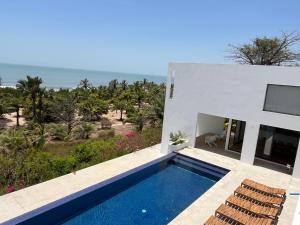 a villa with a swimming pool and a view of the ocean at Maison des Alizés in Oussouye