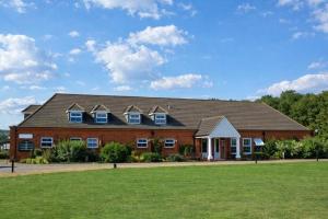 a large brick building with a green field in front at Silverstone Golf Club And Hotel in Silverstone