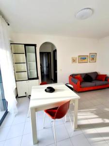 a living room with a white table and a red couch at Sassonia beach in Fano