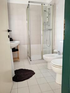 a bathroom with a shower and a toilet and a sink at Sassonia beach in Fano