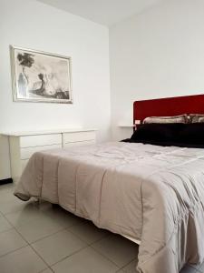 a bedroom with a white bed with a painting on the wall at Sassonia beach in Fano