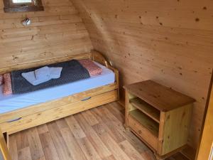 a small room with a bed and a table at Nr 5 Camping Pod mit Terrasse und Seeblick in Langenbernsdorf