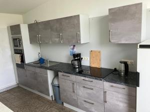 a kitchen with stainless steel cabinets and a counter top at Nr 5 Camping Pod mit Terrasse und Seeblick in Langenbernsdorf