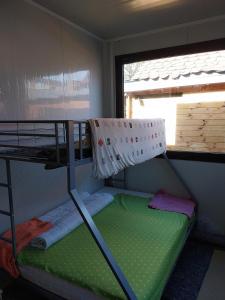 a bunk bed in a small room with a window at Tauber RadApart Kreativhof in Creglingen