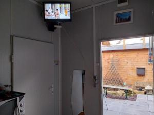 a television on a wall in a living room at Tauber RadApart Kreativhof in Creglingen