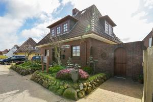 a brick house with a landscaping in front of it at Robbennest in Süderende