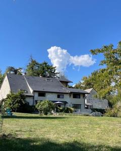 a large house in a yard with a grass field at La Tranquilitude in Ceyzérieu