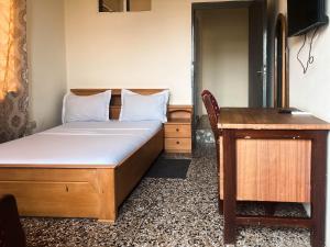 a bedroom with a bed and a desk and a table at Christianborg in Trofwi