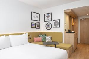 a hotel room with a bed and a couch at Hampton By Hilton Nuneaton in Nuneaton