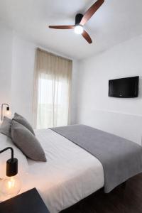a bedroom with a bed with a ceiling fan at Apartamentos Carmen del Turia in Valencia