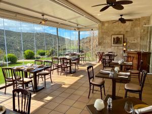 a restaurant with tables and chairs and large windows at Los Cinco Enebros Hotel & Spa by Bossh! Hotels in Robledo de Chavela