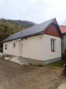 a white house with a red roof at Báránykő Apartman in Pásztó