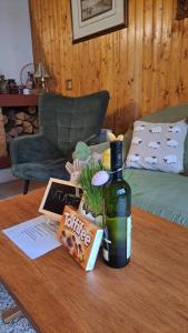 a bottle of wine sitting on a coffee table at Chata Ružín nad Vodou in Margecany
