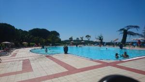 a large swimming pool with people in the water at Residence de bordaberry in Urrugne