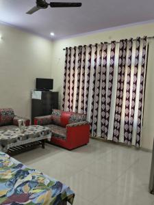 a living room with a couch and chairs and a curtain at RS Homestay in Bareilly