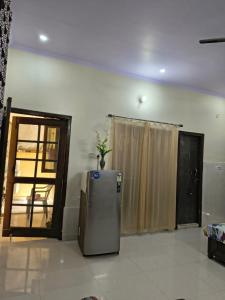 a kitchen with a refrigerator in a room with a door at RS Homestay in Bareilly