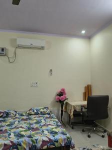 a bedroom with a bed and a desk and a table at RS Homestay in Bareilly +25 photos