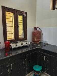 a kitchen counter with a stove and a window at RS Homestay in Bareilly