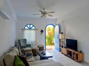 a living room with a couch and a tv at Latchi Holiday House in Prodhromi