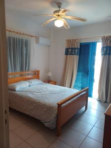 a bedroom with a bed and a ceiling fan at Latchi Holiday House in Prodhromi