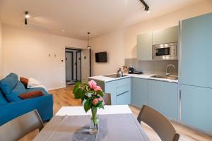 a kitchen and living room with a table and a blue couch at Villa Decimum in Ciampino
