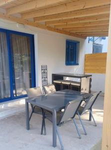 a table and chairs in a patio with a piano at Latchi Holiday House in Prodhromi