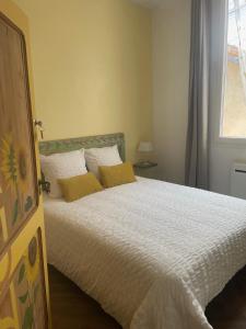 a bedroom with a bed with two yellow pillows at couleurs d'ici in Fleurance