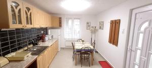 a kitchen with a table and chairs in it at Báránykő Apartman in Pásztó