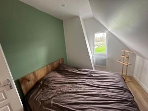 a bed in a room with a green wall at La Houblonnière Eperlecques Gite d'Ecou in Tilques +6 photos