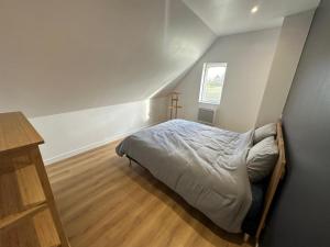 a bedroom with a bed and a cross on the wall at La Houblonnière Eperlecques Gite d'Ecou in Tilques